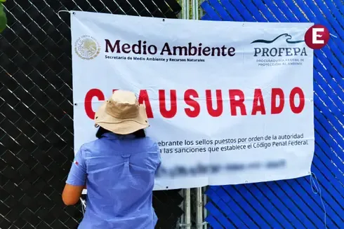 A person is seen standing in front of a large banner that reads "CLOSED" in Spanish, indicating a site closure by environmental authorities.$
