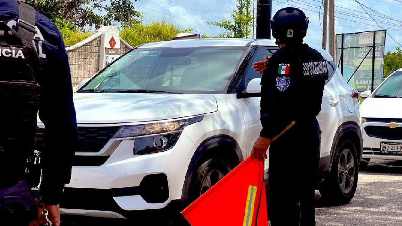 A police officer directing traffic with a red flag near a white SUV in an urban area.$# CAPTION