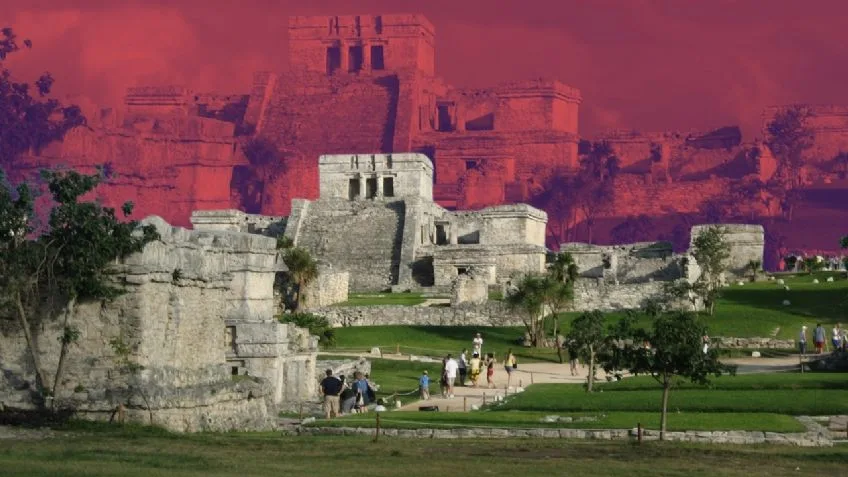 A view of the ancient ruins of Tulum with a colorful, dramatic sky in the background, highlighting the intricate architecture of the structures and the lush green landscape surrounding them.$#$ CAPTION