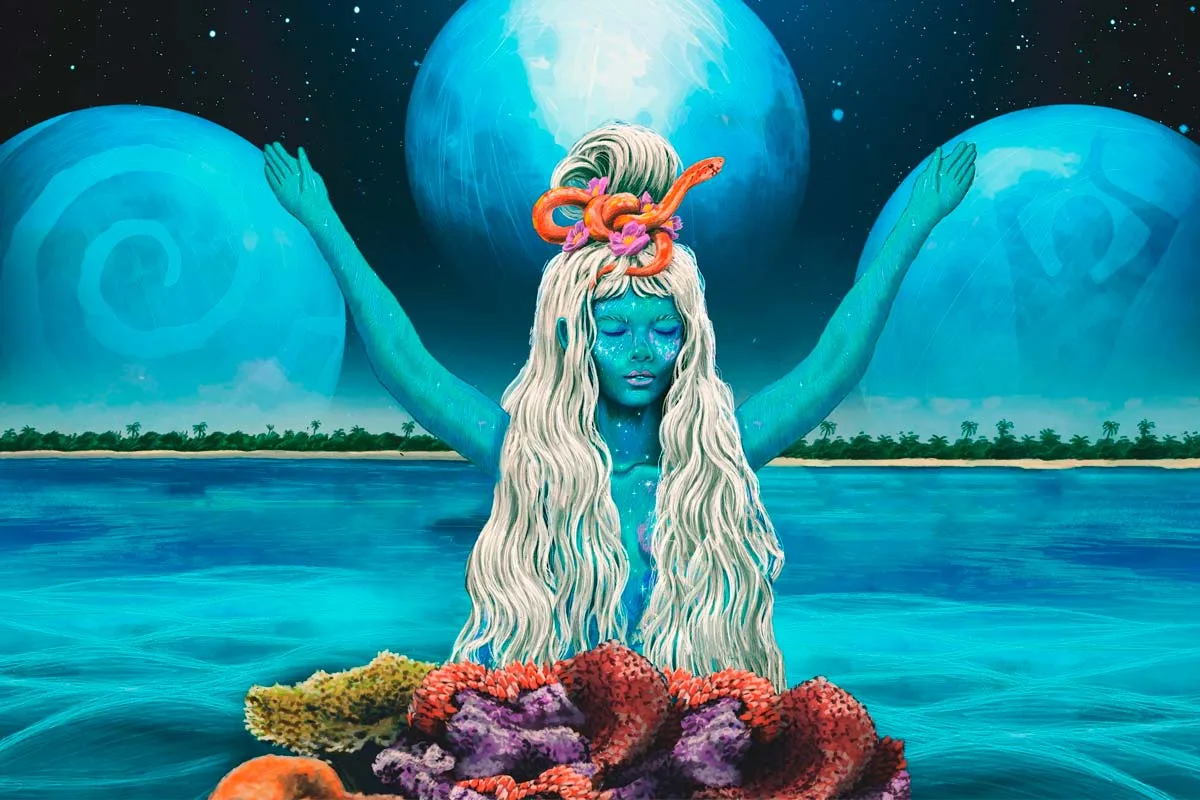 A mystical figure with long white hair, blue skin, and an orange snake in her hair, standing in the water with arms raised, surrounded by coral and planets in the background.$# CAPTION