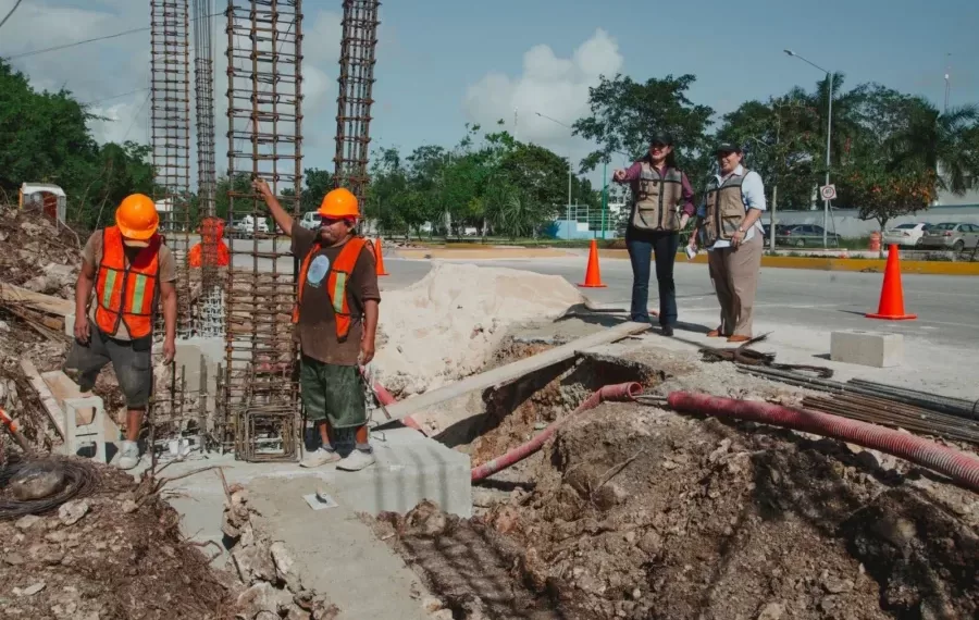 Workers and inspectors at a construction site with rebar structures and safety gear in view
