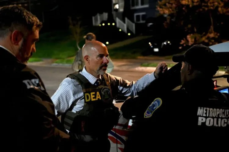 DEA and Metro Police officers communicate during a night operation.$# CAPTION
