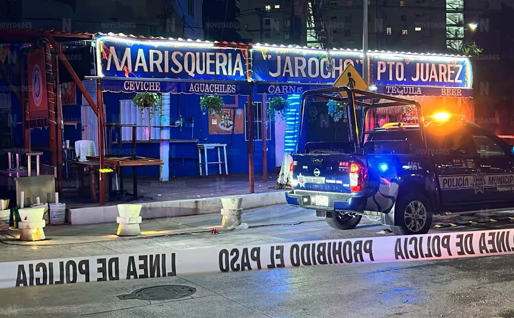 Police vehicle at a seafood restaurant with caution tape and vibrant signage at night