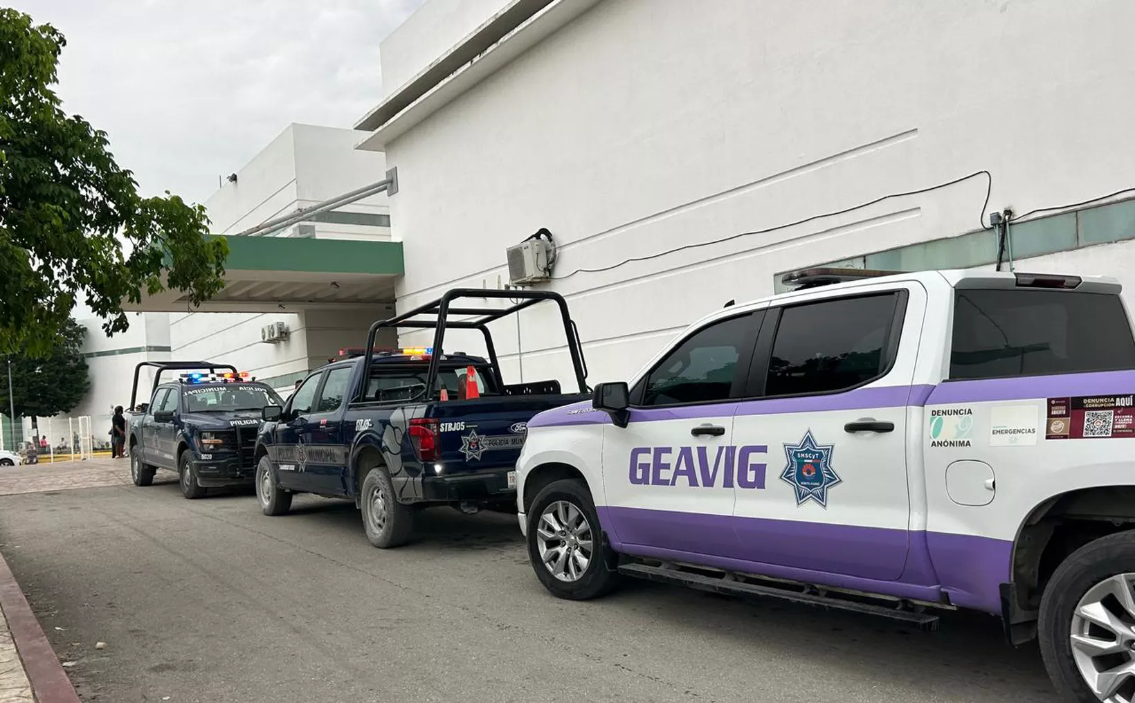 Multiple police vehicles parked outside a building, showcasing the presence of law enforcement in the area.$#$ CAPTION