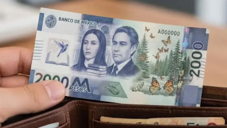 A hand holding a 2000 pesos banknote from Mexico displayed in a wallet