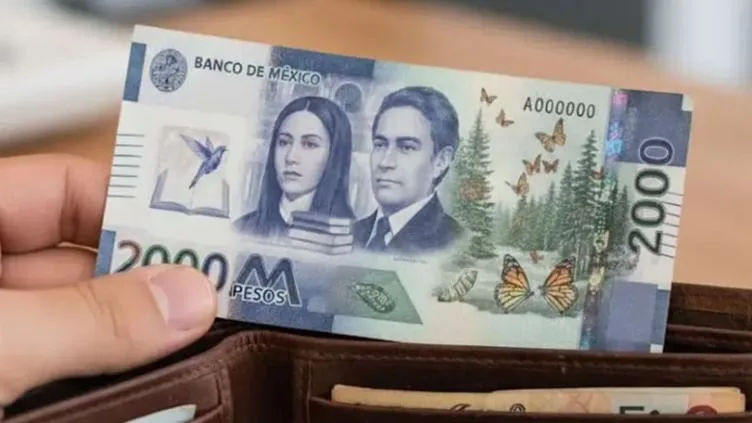 A hand holding a 2000 pesos banknote from Mexico displayed in a wallet