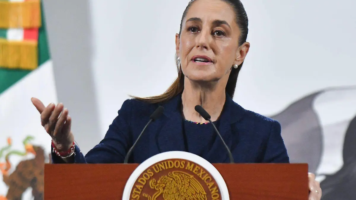 A woman speaking at a podium with the emblem of Mexico in the foreground and the flag in the background.$# CAPTION