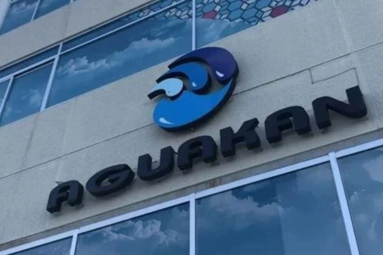 Sign for Aguakan, a water services company, mounted on a building wall.$#$ CAPTION