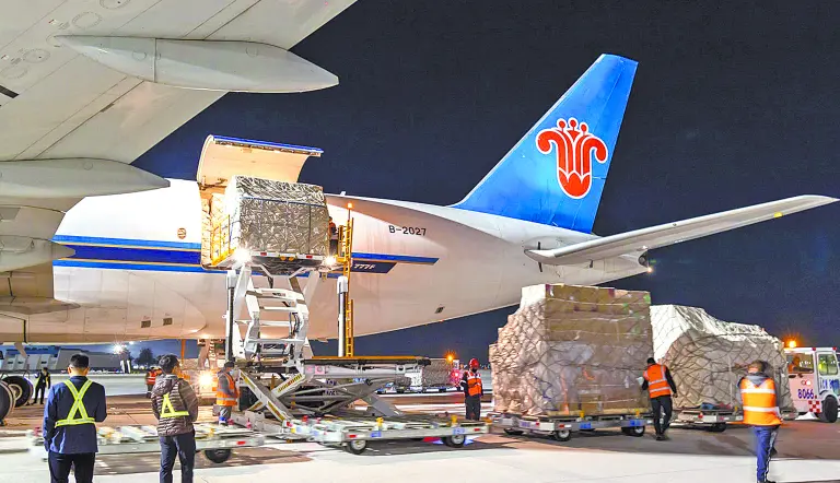 Workers loading cargo onto a China Southern Airlines plane at night