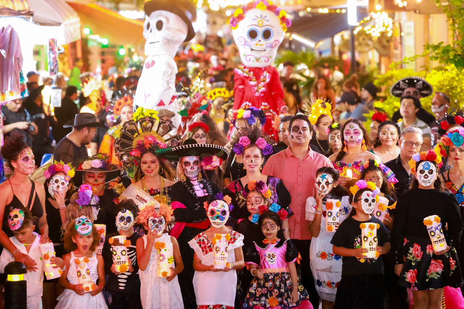 Participants embrace the spirit of Dia de los Muertos, showcasing their elaborate costumes and painted faces in a joyful parade, symbolizing the celebration of life and remembrance of loved ones.
