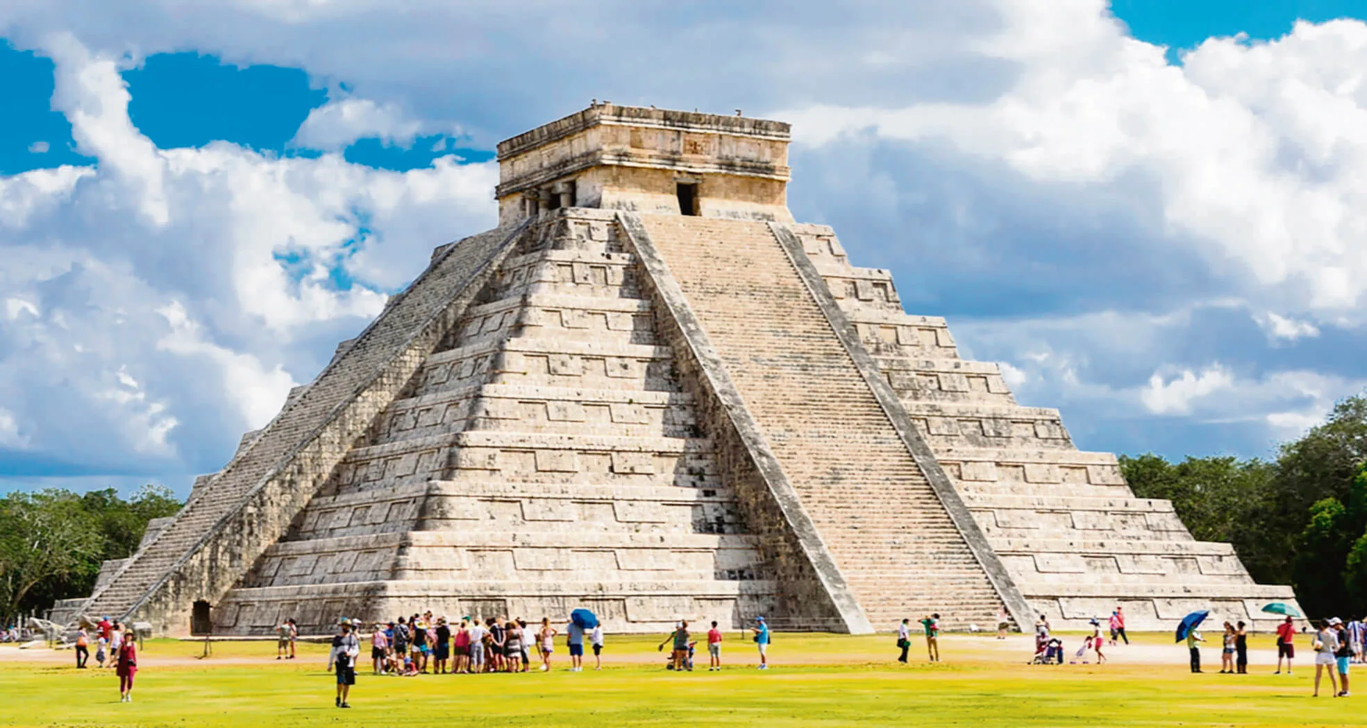 ancient Mayan pyramid at Chichen Itza with visitors exploring the site