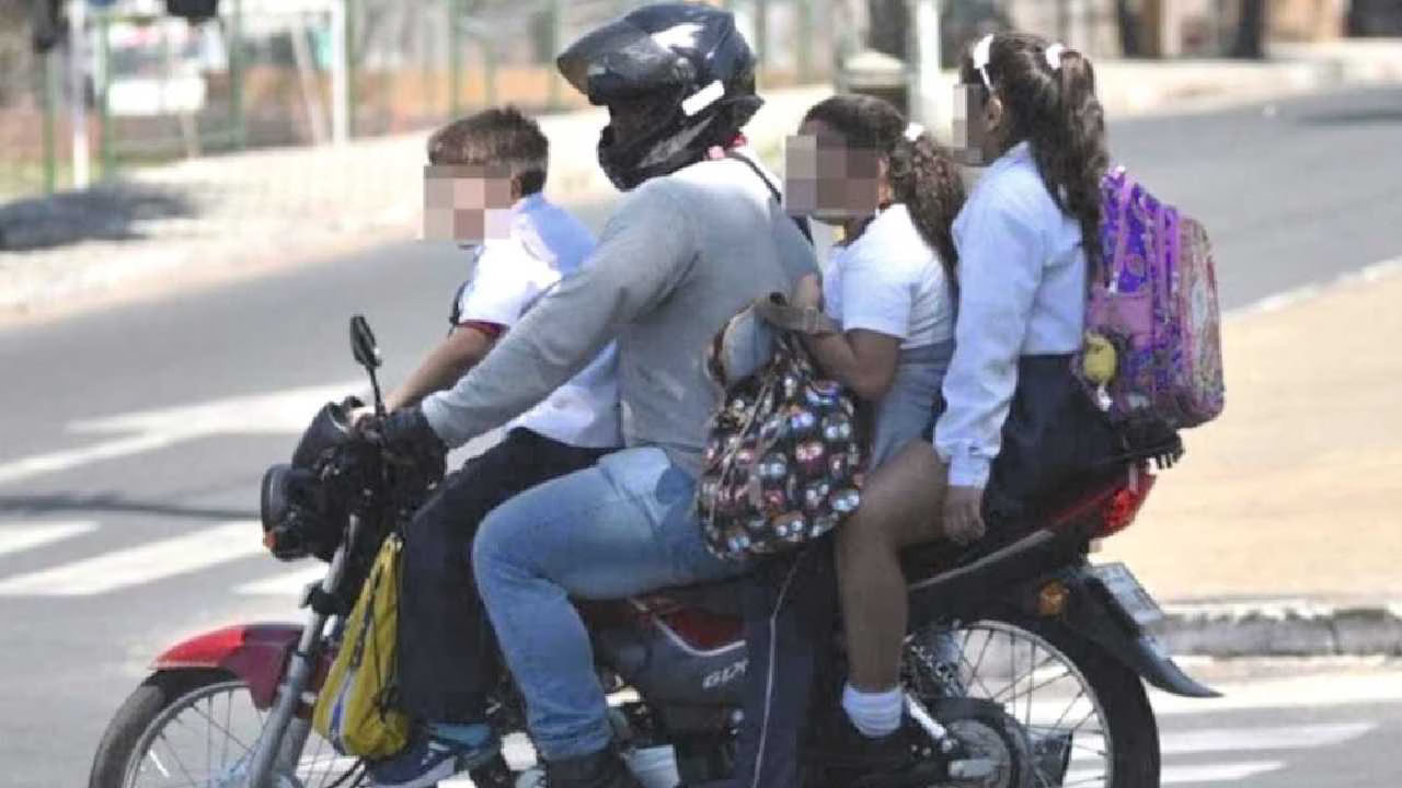 an adult and three children on a motorcycle in a city street-20102025