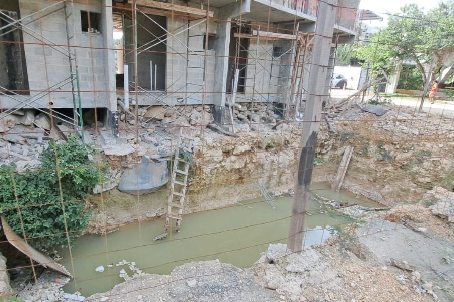 a construction site showing scaffolding and a waterlogged area below-26102025