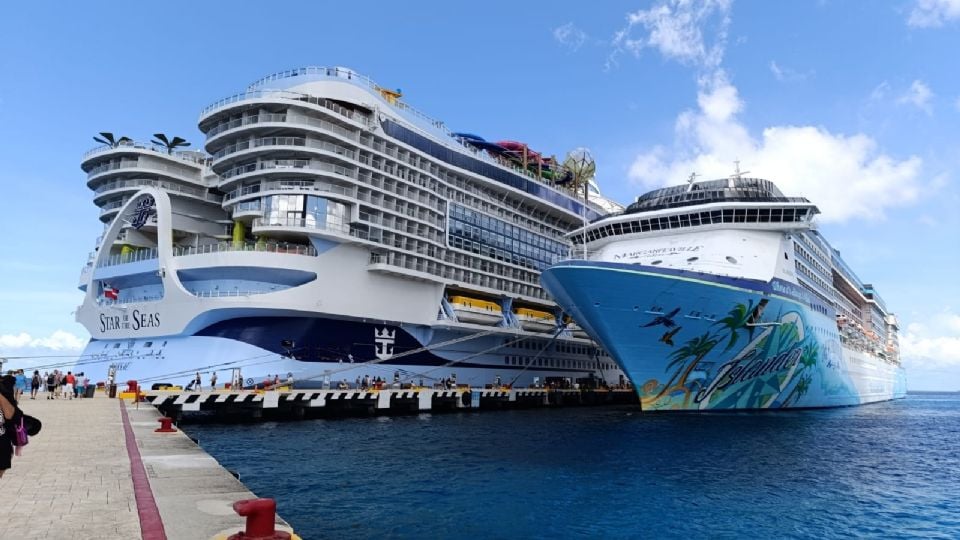 two large cruise ships docked side by side on a sunny day