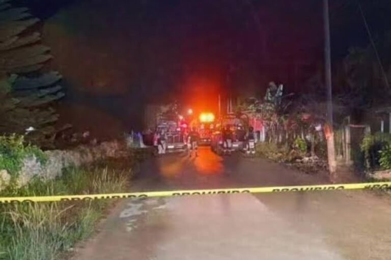 A night scene showing emergency vehicles and personnel behind police tape on a dimly lit street with greenery along the side.$# CAPTION