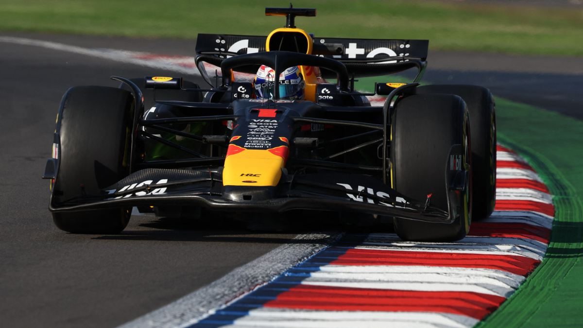 A Formula 1 car navigating a curvy race track with colorful painted curbs.$# CAPTION