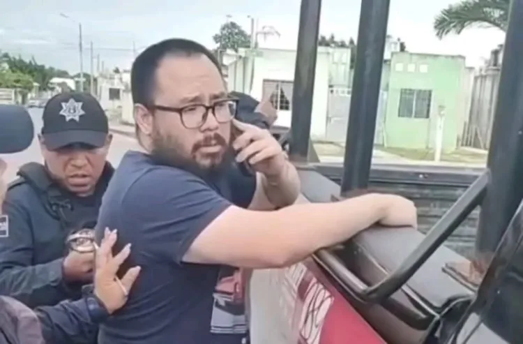 A man talking on the phone while being approached by police officers in an urban environment.