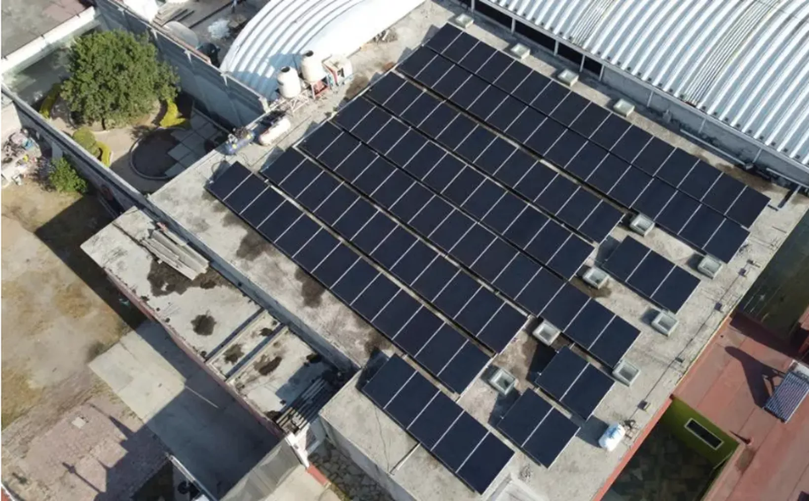 Aerial view of a rooftop filled with solar panels, showcasing sustainable energy efforts in urban architecture.$# CAPTION