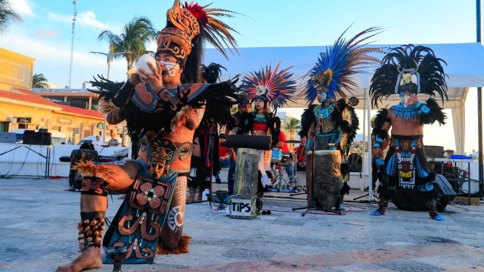 a group of performers dressed in traditional Aztec costumes performing on stage-25102025