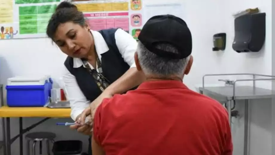 A healthcare professional administering a vaccination to a patient in a clinic setting.$# CAPTION