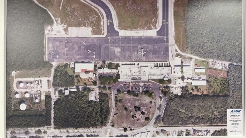 aerial image showing an airport layout with parking areas runways and nearby vegetation