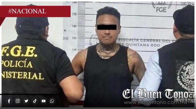 A man standing in a police lineup with two officers next to him, one wearing a vest that says "F.G.E. Policía Ministerial." The background displays measuring lines for height. The man's identity is obscured. $#$ CAPTION