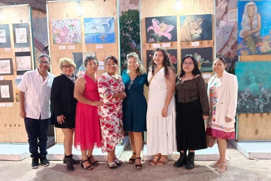 a group of seven individuals standing together in front of artwork at an exhibition-18112025