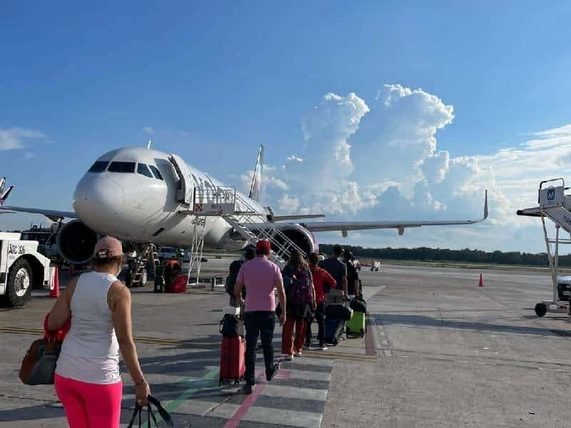 passengers walking towards an airplane on a clear sunny day at the airport