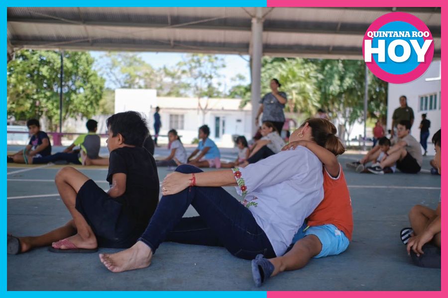a group of children sitting on a court with one adult interacting with a child-08112025