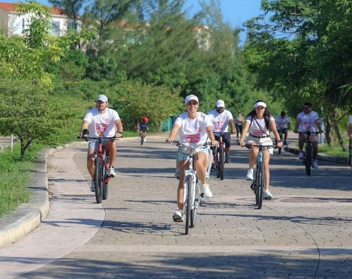 a group of people riding bicycles on a path surrounded by greenery in quintana roo