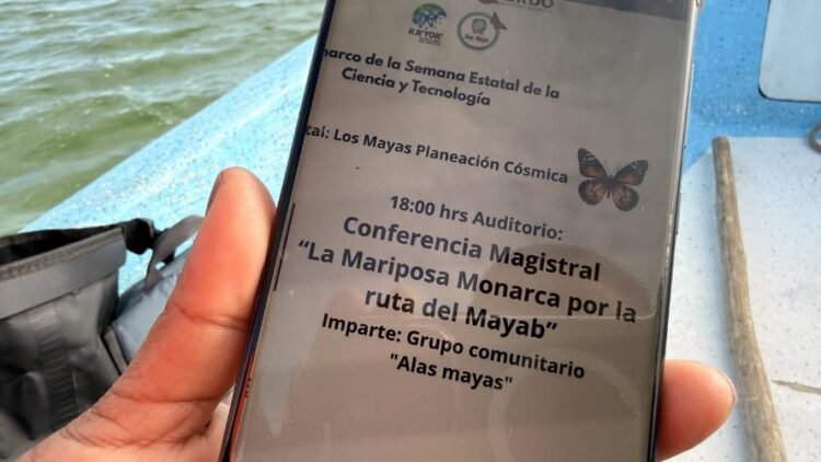 a smartphone displaying details of a conference about the monarch butterfly and its conservation on a boat near water