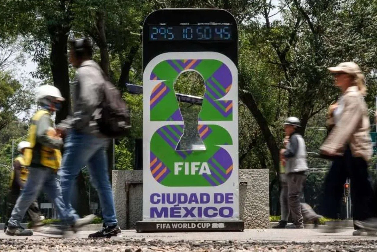 a digital countdown clock for the FIFA World Cup with people walking by in Mexico City