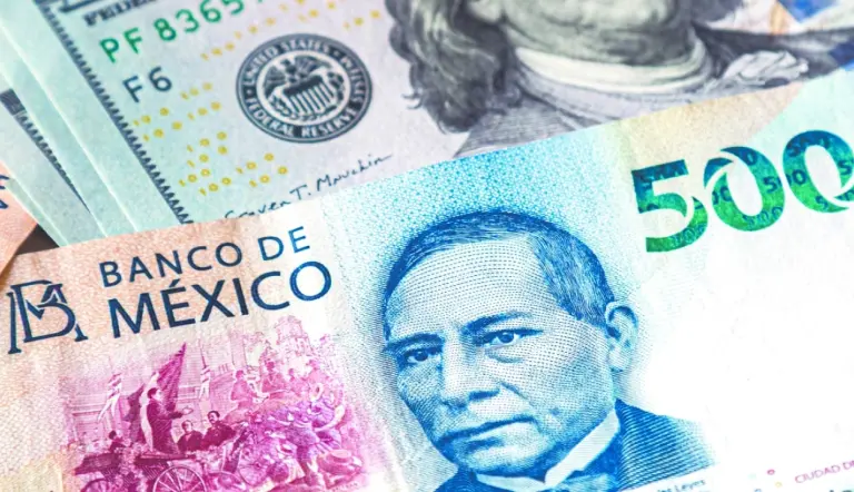 Close-up of Mexican banknotes alongside US dollar bills, highlighting a 500 peso note with a prominent figure's portrait.