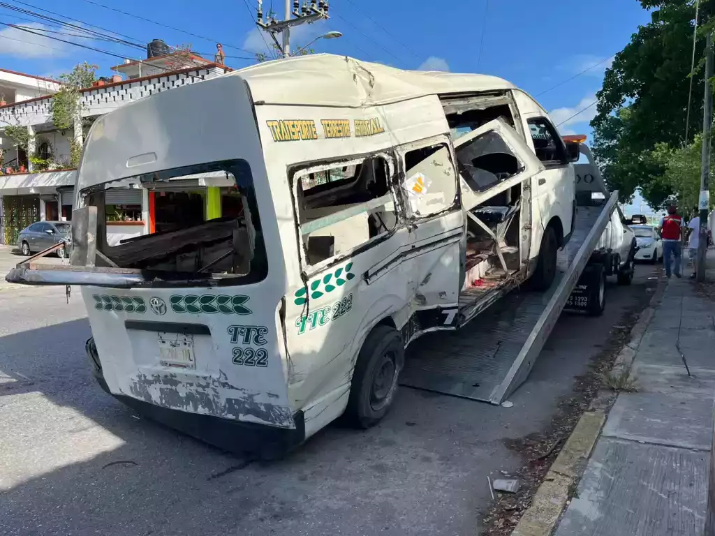 a damaged van being loaded onto a tow truck with visible destruction on the side-$# CAPTION