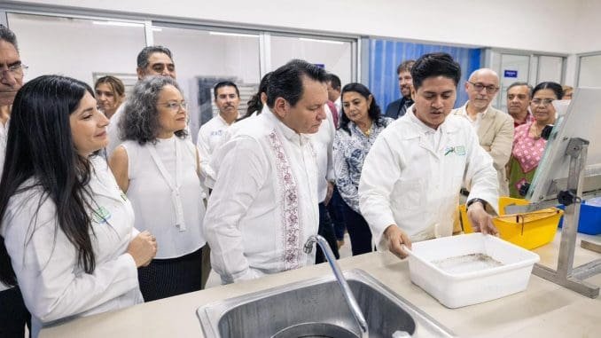a group of people observing a presentation on fish farming techniques in a laboratory setting