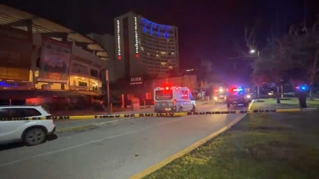 a nighttime scene showing emergency vehicles and police cordon near a building-17112025