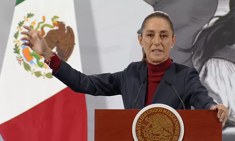A politician giving a speech at a podium with the Mexican flag in the background and a presidential seal on the front