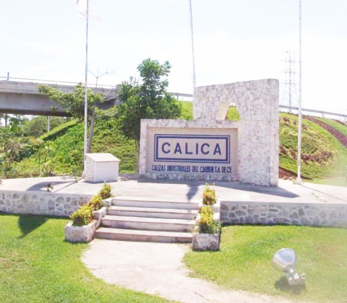 A stone entrance sign for CALICA, surrounded by greenery and a few flowers, indicating the CALICAS INDUSTRIALES DEL CARMEN SA DE CV industrial complex.$#$ CAPTION