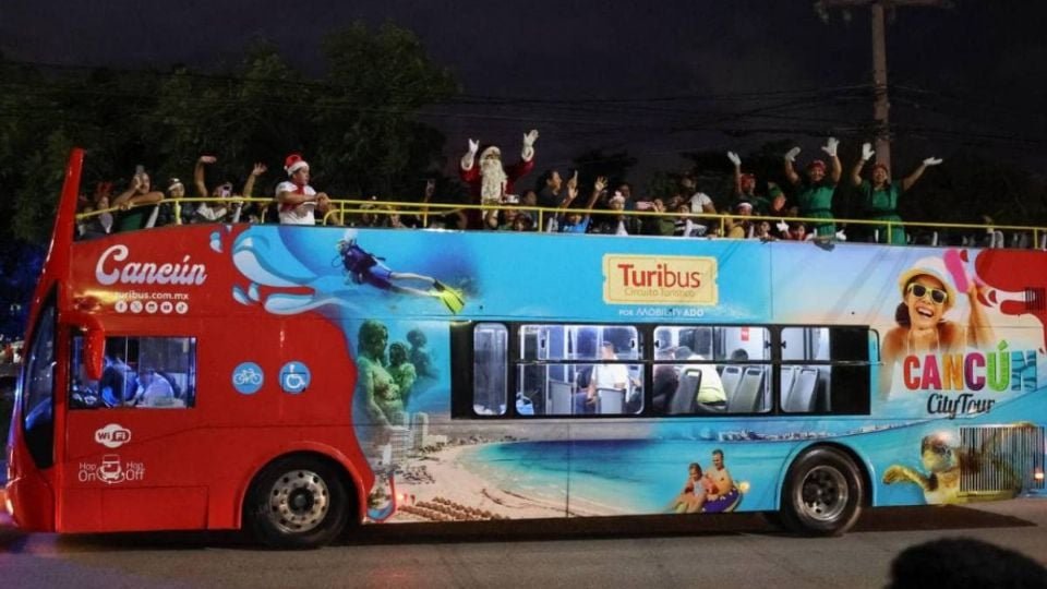 a decorated open-top bus in cancun with festive characters and people celebrating on board