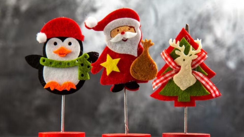 three felt holiday decorations including a penguin a Santa Claus and a Christmas tree with a reindeer