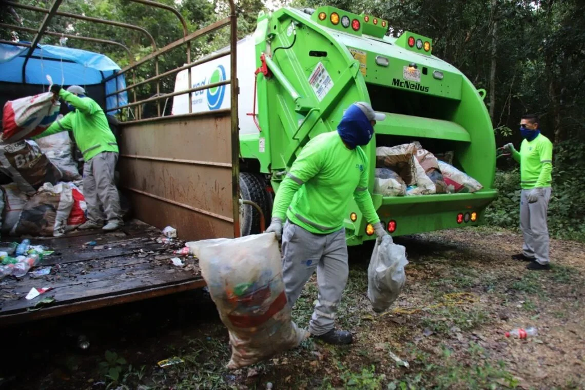 workers collecting garbage from a truck in a forested area