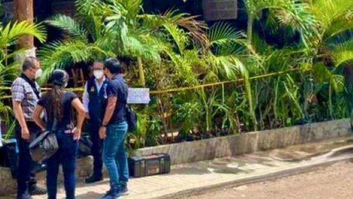 A group of people in masks conversing outdoors surrounded by greenery.$# CAPTION