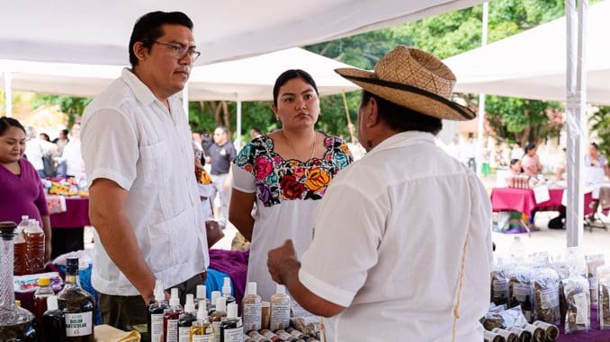 people discussing herbal products at a market-09112025