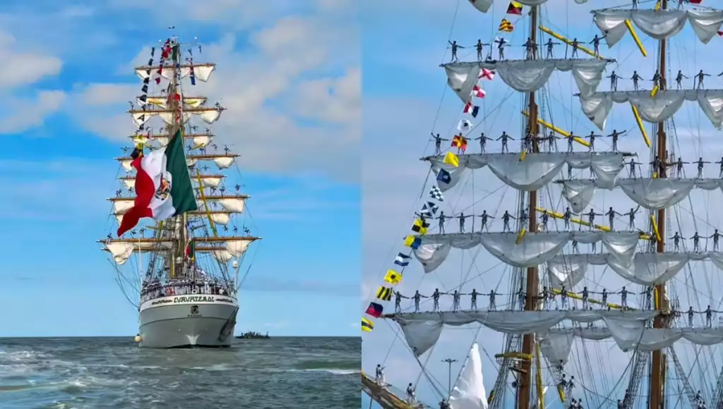 a tall ship with sails and flags sailing on a clear day