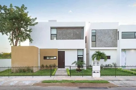 A contemporary house featuring a mix of white and grey exterior with a landscaped front yard and a fence.