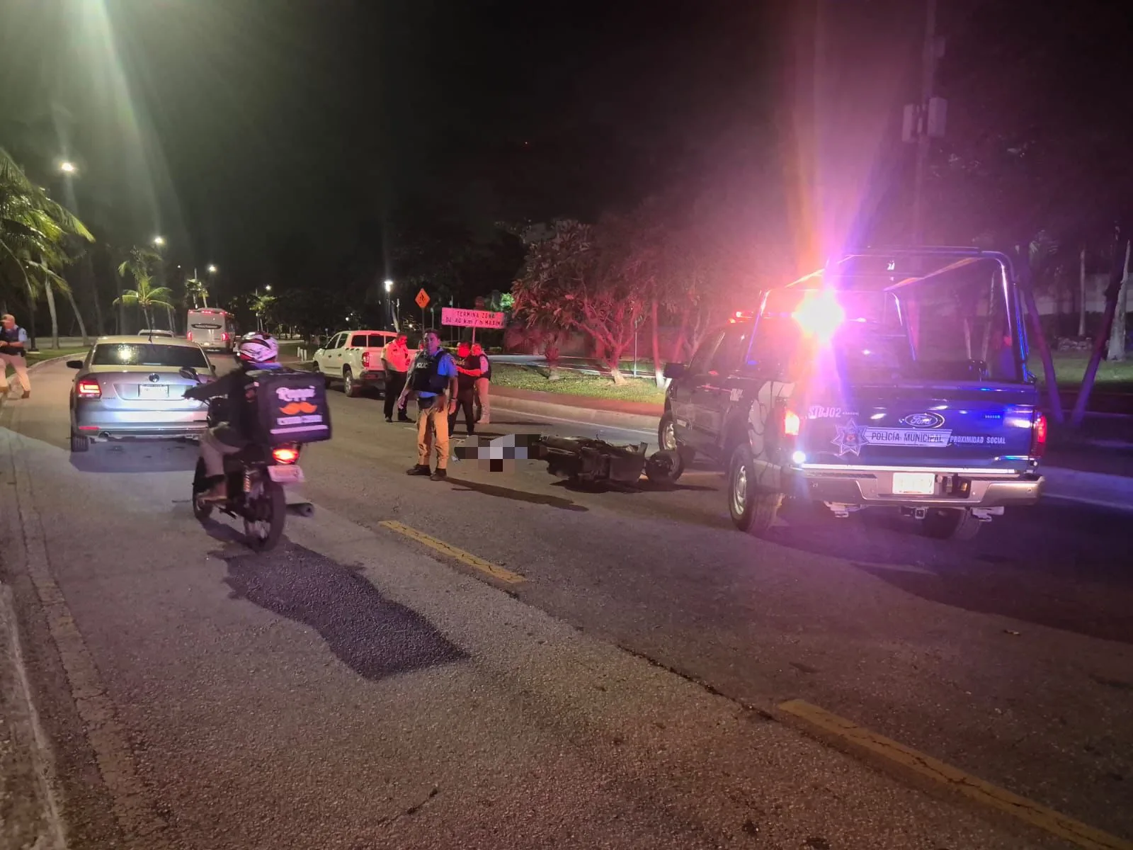 Scene of a motorcycle crash in Cancun's Hotel Zone showing emergency response