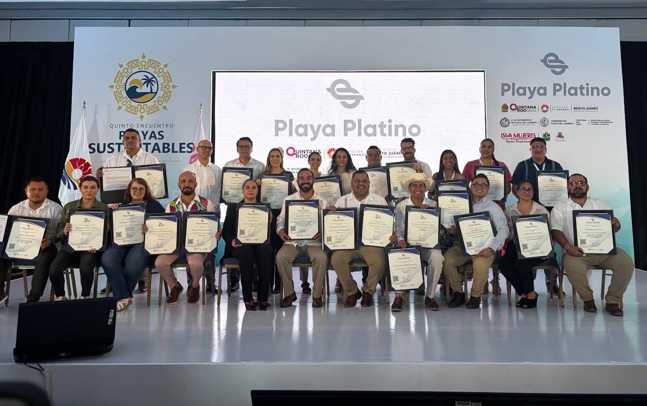 A group of individuals holding certificates at the Playa Platino certification ceremony, with a backdrop featuring the Playa Platino logo and event branding.$# CAPTION