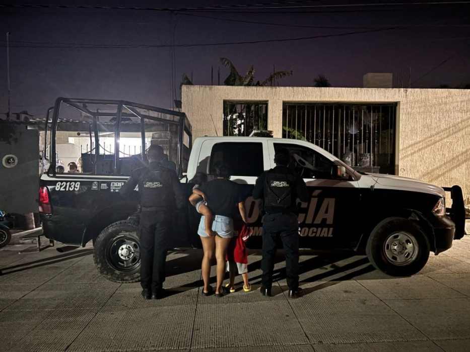 Three individuals, including a child, are with police officers near a police vehicle at night. The scene has a casual urban backdrop.$# CAPTION