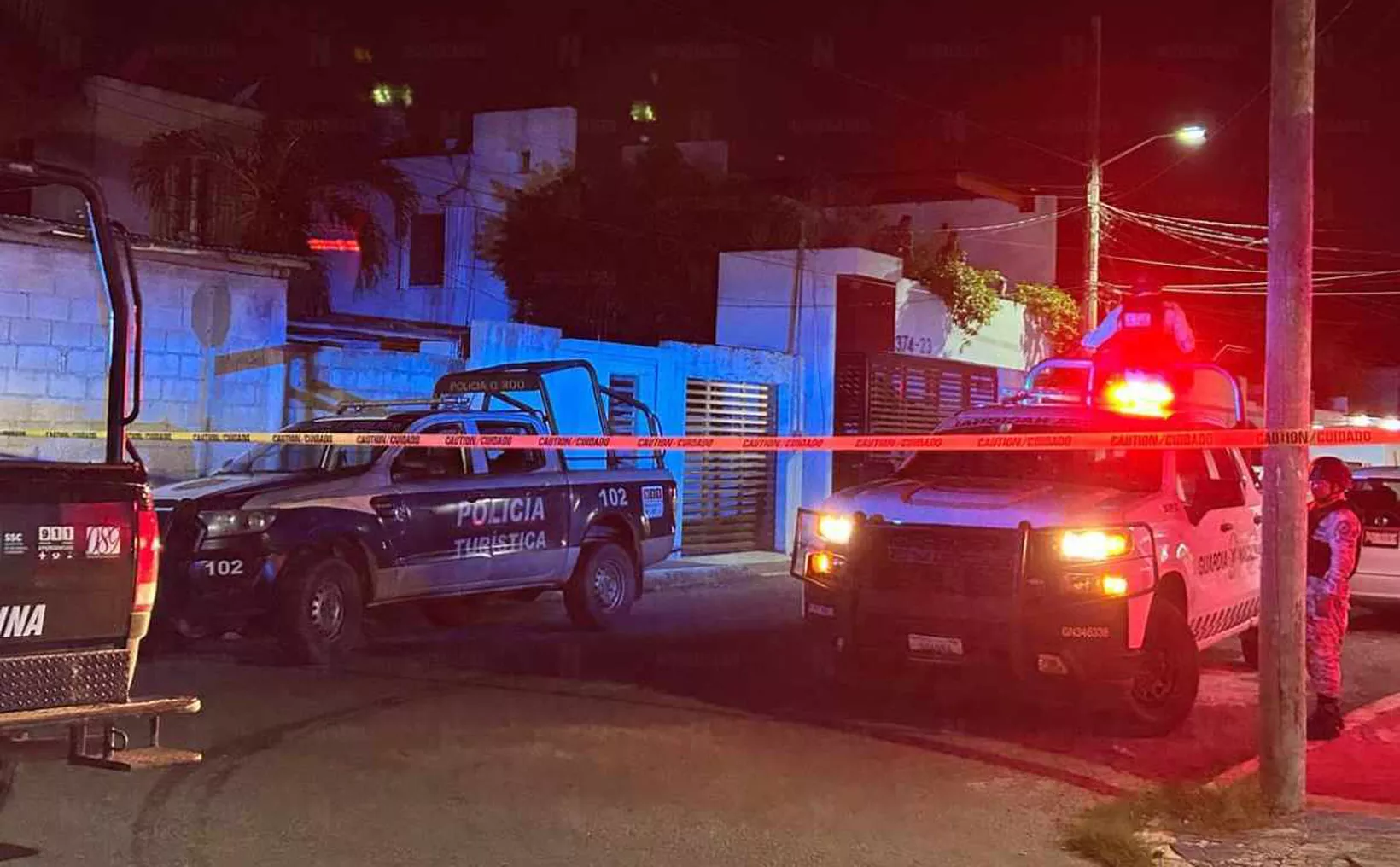 Emergency vehicles with flashing lights at a nighttime location surrounded by caution tape.$# CAPTION