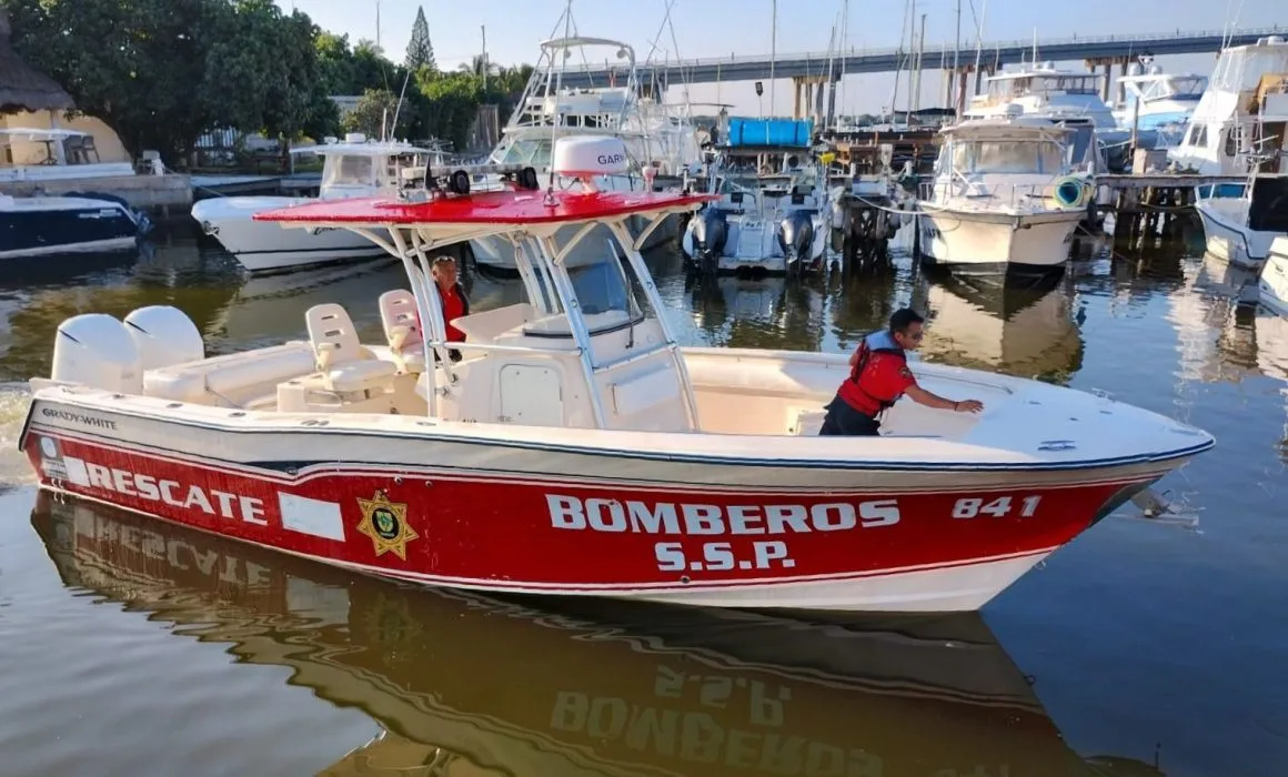 A rescue boat labeled 'BOMBEROS S.S.P.' at a marina, with crew members preparing for departure.$#$ CAPTION